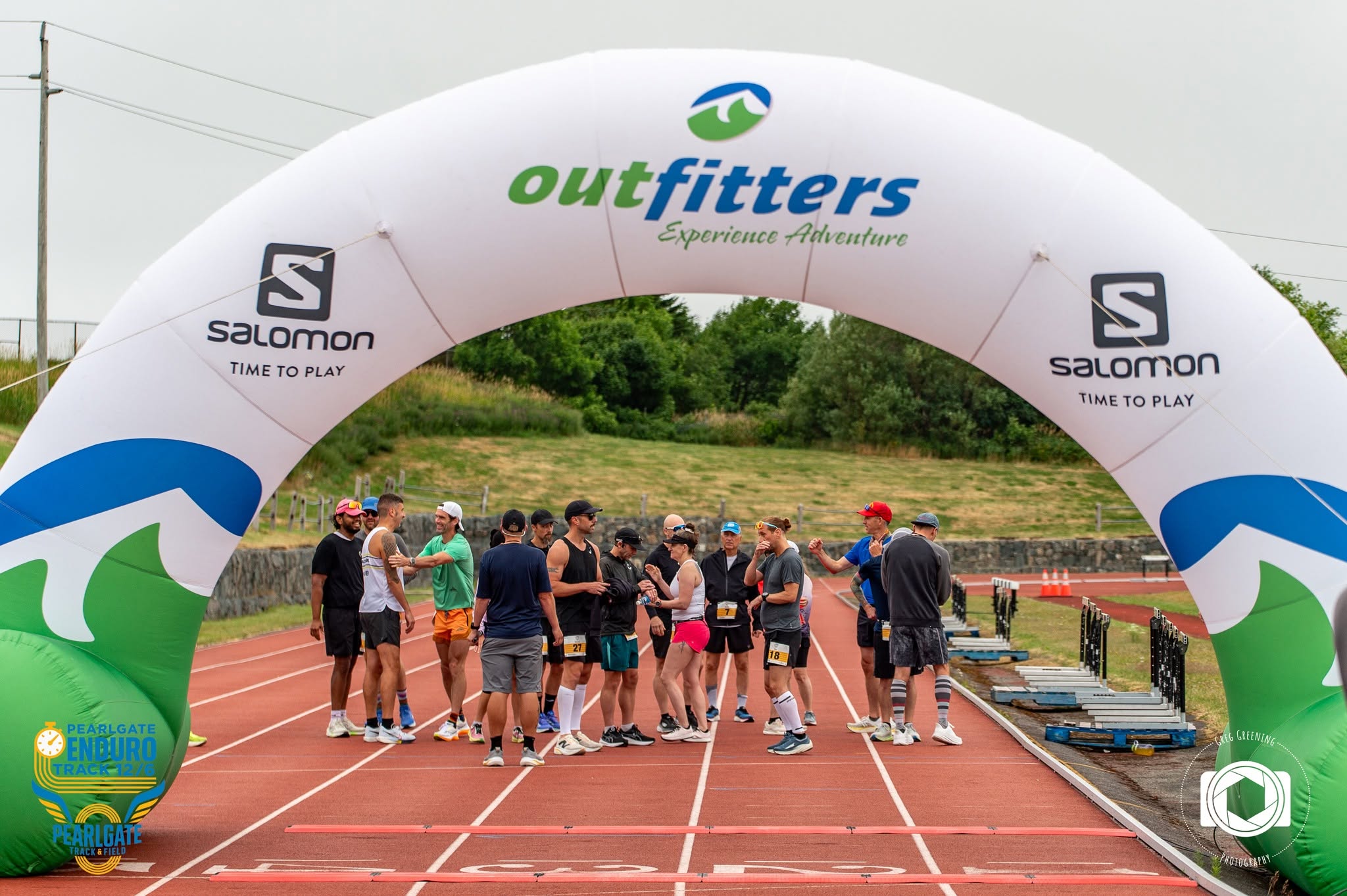 Athletes gathered beneath the start arch at the Pearlgate track